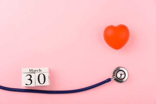 Doctor's Day concept, flat lay top view, equipment medical red heart and stethoscope on pink background, care patient in hospital with copy space for text