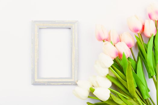 Happy Women's Day, Mother's Day and Valentine's Day concept. top view flat lay Tulip flower and photo frame on white background, copy space for your text