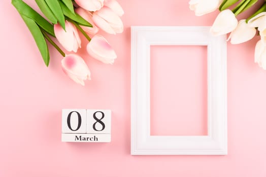 Happy Women's Day, Mother's Day concept. top view flat lay Tulip flower and photo frame on pink background, copy space for your text
