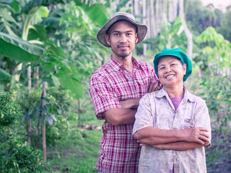 Asian agriculturist, mother and son, in their garden, Thailand