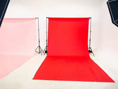 A photography studio is prepared for photography, with red and pink background prepared.