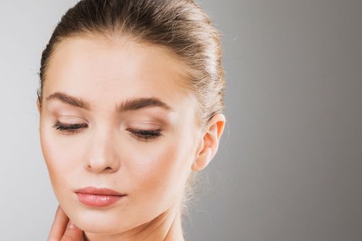 Young beautiful woman face portrait with healthy skin, eyes closed