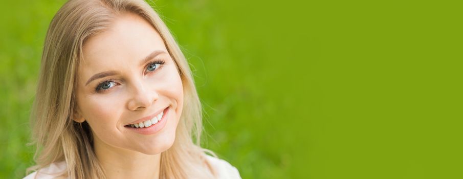 Beautiful woman portrait on spring grass meadow copy space