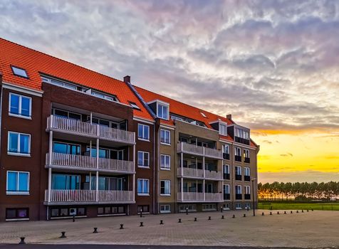 apartments building with the street during sunset in Sint Annaland, touristic town in zeeland, The Netherlands