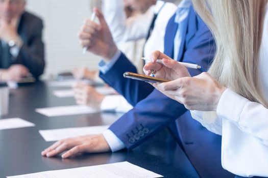 Business people working with documents in conference room focus at woman with phone