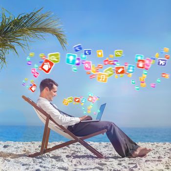 Young businessman on his beach chair using his laptop with colourful computer applications