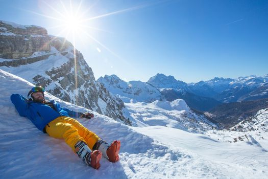 Alpine skier lay in winter mountains Dolomities Italy in beautiful alps Cortina d'Ampezzo Cinque torri mountain peaks famous landscape skiing resort area enjoy sunlight