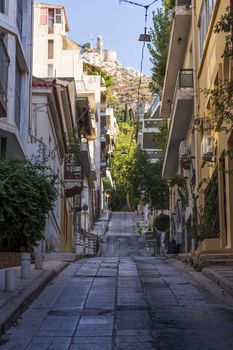 Narrow street scene in Athens with a view of filopappou hill. Greece.