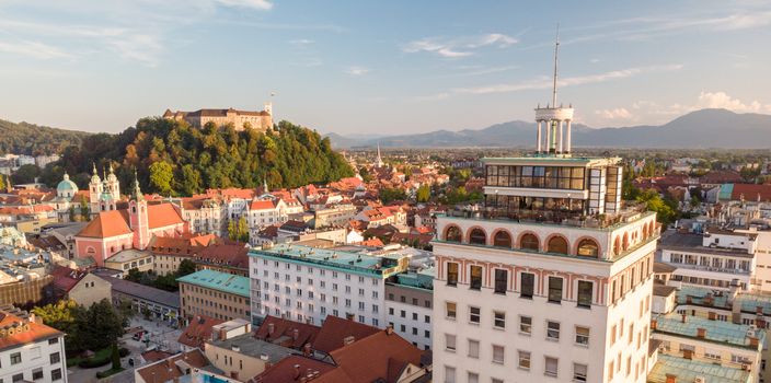Aerial panoramic view of Ljubljana, capital of Slovenia in warm afternoon sun. Old skyscraper of Ljubljana with it's panoramic rooftop terrace dominating the skyline.