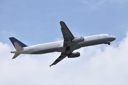 Plane taking off among clouds and blue sky