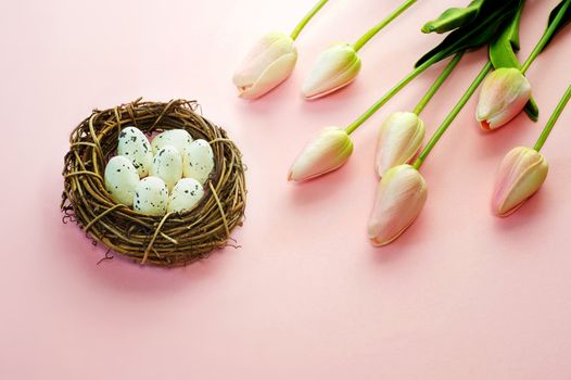 Easter eggs and tulips on wooden planks.