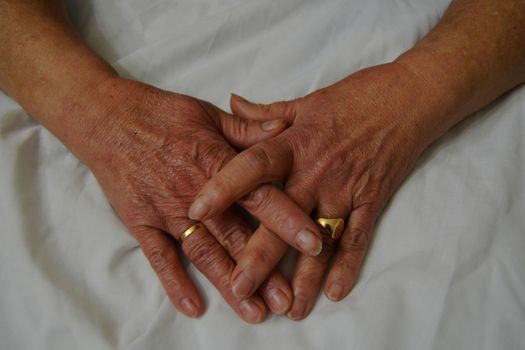 Hands of an old woman, old, clean with rings and other ornaments.