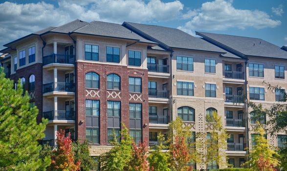 A modern brick and stucco apartment building with nice landscaping