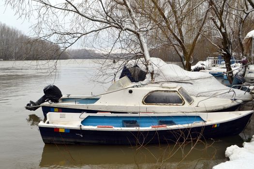 High water winter on the Borcea arm at the end of winter.
Boats, pontoons anchored by metal fences float on the great waters