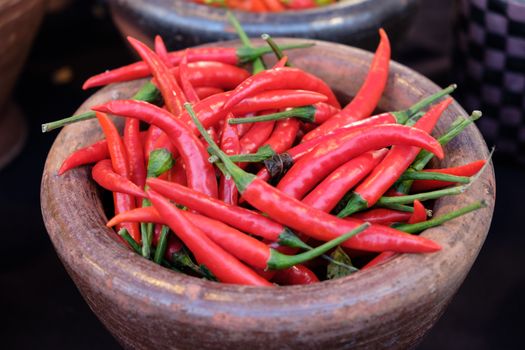 Chili peppers in clay pot red, chili peppers in Old style ceramic bowl . Top view.