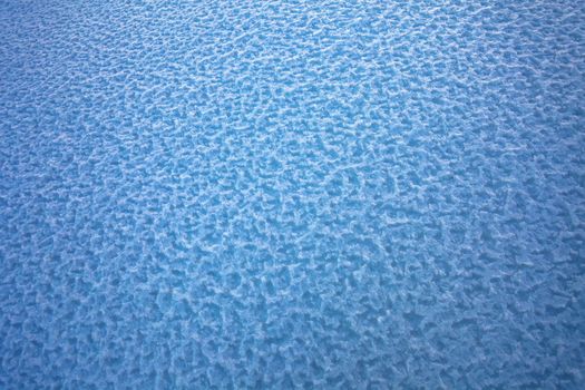 Background of frozen snow texture in blue tone field, in the winter season