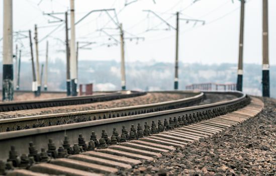 old railroad rails and poles with wires without a train without people