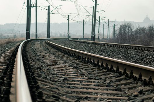 old railroad rails and poles with wires without a train without people