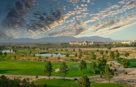 A resort golf course in the desert with mountains in the background