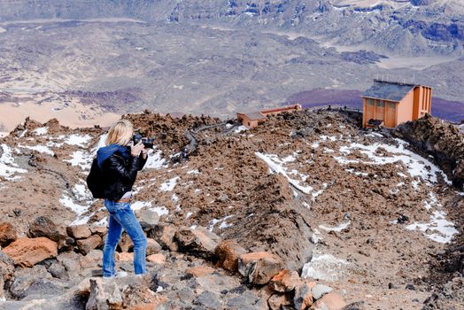 Photographer taking picture of cable car station at the foot of the Teide volcano. National Park Teide, Tenerife, Canary Islands