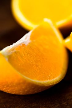 Sliced close up oranges on dark background with selective focus