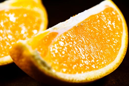 Sliced close up oranges on dark background with selective focus