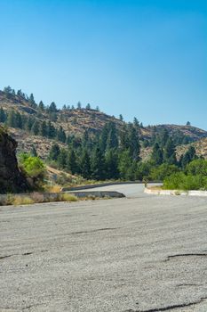 Asphalt road leading uphill to the mountains. Four lane highway on hot summer day