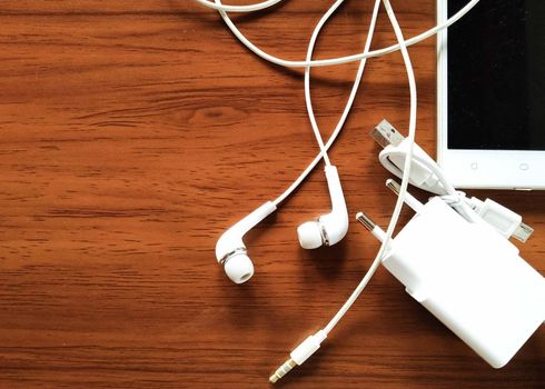 USB cables, charging cables, as well as many other connecting cables, are placed on a wooden table.