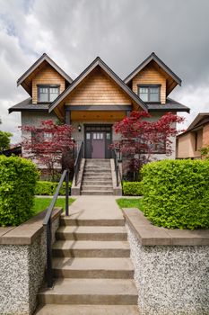 Luxury family house with stairwell over front yard on land terrace. Expensive residential house