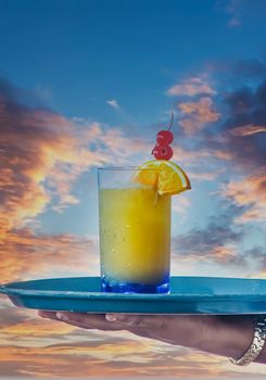 Tropical Drink Carried on Tray Over Sunset