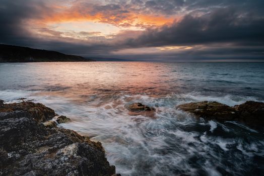 Portmuck, Islandmagee, County Antrim, Northern Ireland: A sunset and cloud formation create the appearance of a fiery hole in the sky.