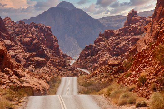 A highway rolling through red rock canyons in Nevada