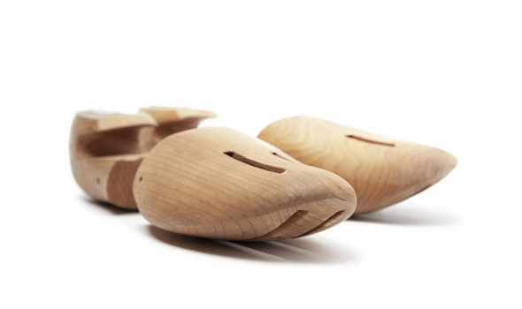 Selective focus of men's wooden shoe stretcher isolated on a white background
