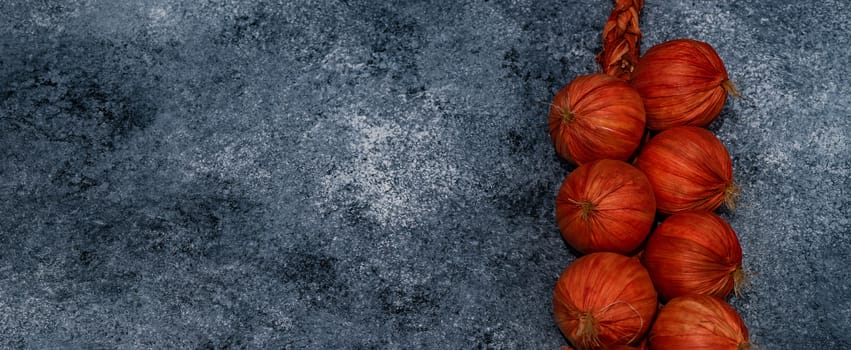 Red onion harvest on stone background as autumnal harvest