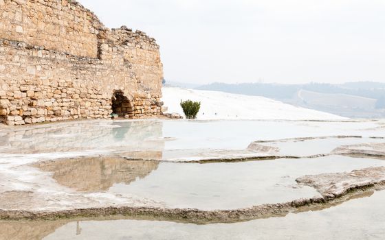 The view across a hot spring towards a ruined building in Hierapolis, southwestern Turkey.  The site is a UNESCO World Heritage Site.