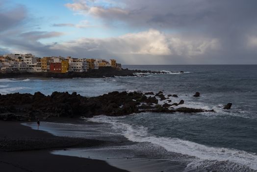 Puerto de la Cruz, Tenerife, Spain -Jaunary 9, 2020:  Sunset view to cape Punta Brava from Famous beach Playa Jardin with black sand in Puerto de la Cruz, Tenerife, Spain