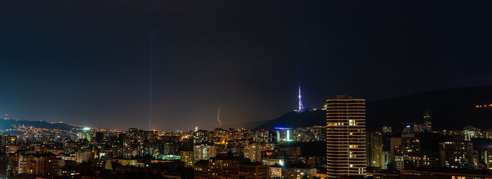 Storm and flashlight over the night sky over Tbilisi's downtown