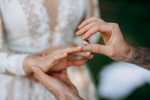 groom puts bride on wedding ring