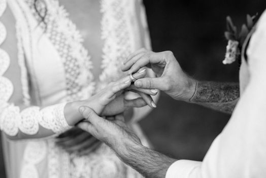 groom puts bride on wedding ring