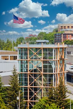 A climbing wall inside a steel and glass tower with American flag in background