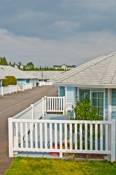 Residential house with chair and decorative tree on patio deck with white fence