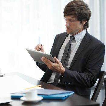 Business man with tablet pc working at office desk