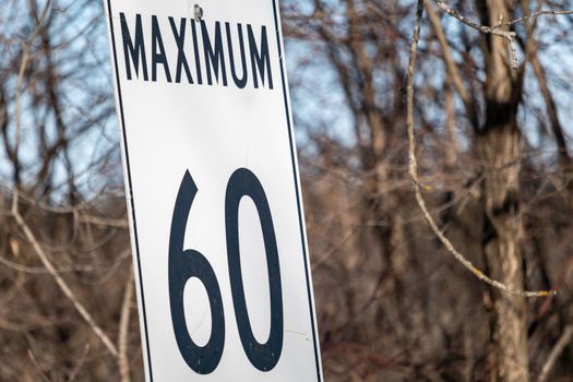 A speed limit sign is positioned in a frame to show the word 'Maximum' and the number sixty (60), but no unit of measurement is shown.
