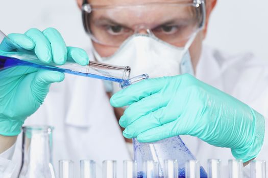 Mature male researcher carrying out scientific research in a lab, Chemistry experiments close up