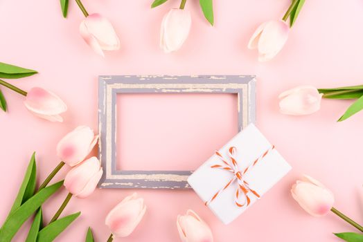 Happy Women's Day, Mother's Day concept. top view flat lay photo frame, gift box and Tulip flower on pink background, copy space for your text