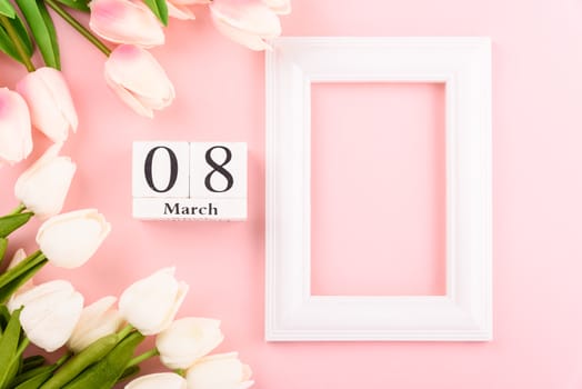 Happy Women's Day, Mother's Day concept. top view flat lay Tulip flower and photo frame on pink background, copy space for your text