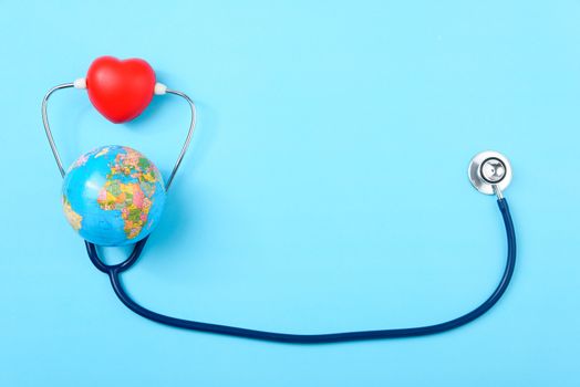 World health day concept, Stethoscope, globe and red heart on blue background with copy space. Global health care