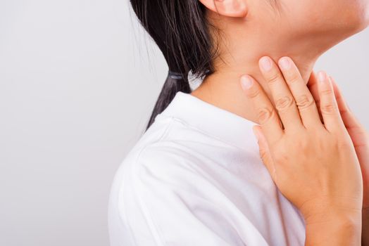 Asian beautiful woman Sore Throat or thyroid gland problem her useing Hand Touching Ill Neck on white background with copy space, Medical and Healthcare concept