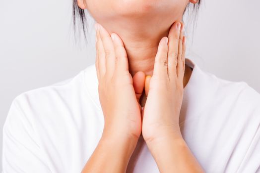 Asian beautiful woman Sore Throat or thyroid gland problem her useing Hand Touching Ill Neck on white background with copy space, Medical and Healthcare concept