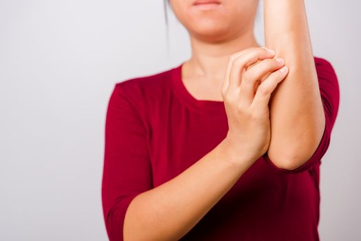 Asian beautiful woman itching her scratching her itchy arm on white background with copy space, Medical and Healthcare concept